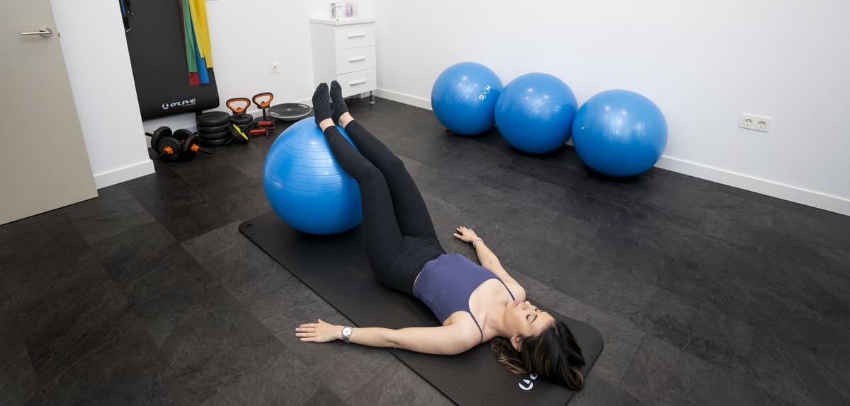 Paciente practicando Pilates en la sala de ejercicio terapéutico de FisioSpace Génova, clínica de fisioterapia en Madrid, para mejorar la flexibilidad, movilidad y fuerza muscular.
