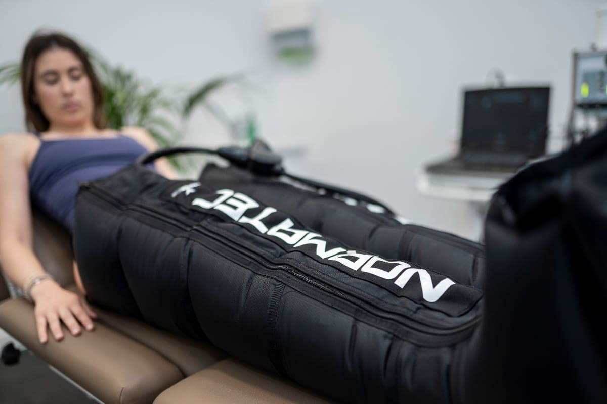 Paciente recibiendo tratamiento de presoterapia en FisioSpace Génova, clínica de fisioterapia avanzada en Madrid, utilizando tecnología Normatec para mejorar la circulación y acelerar la recuperación