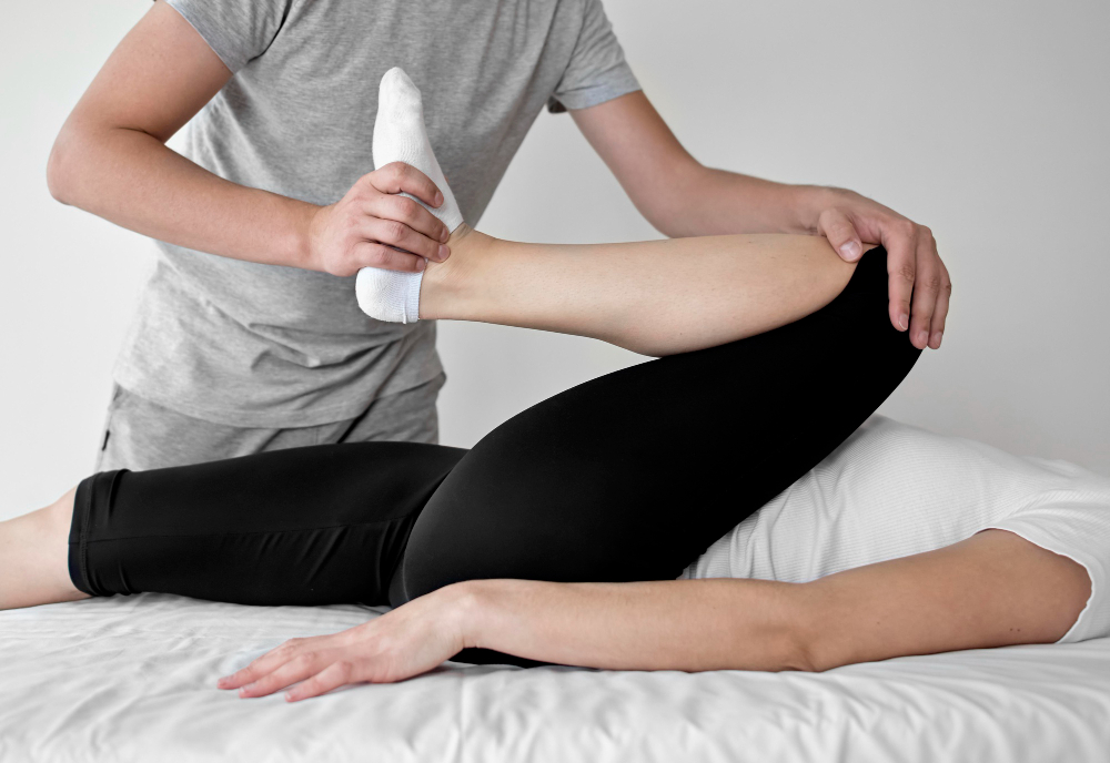 Fisioterapeuta moviendo la rodilla de un paciente, ilustrando técnicas de movilidad articular.