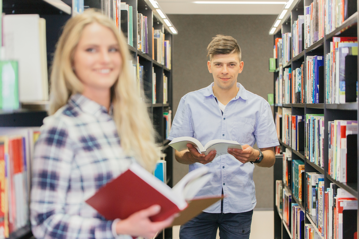 Estudiantes leyendo sonrientes tras obtener buenos resultados académicos.