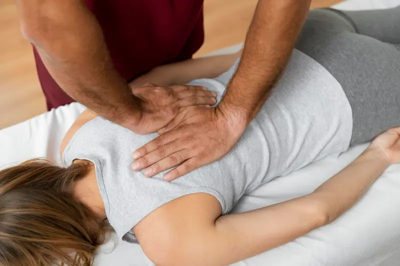 Fisioterapeuta realizando manipulación vertebral en la zona dorsal para tratar el dolor