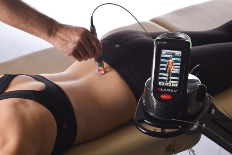 Fisioterapeuta aplicando láser de alta potencia en la zona lumbar